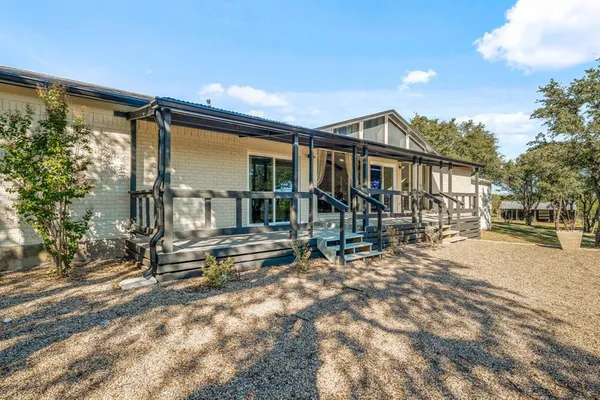 a view of a house with a yard and wooden fence