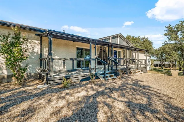 a view of a house with a yard and wooden fence