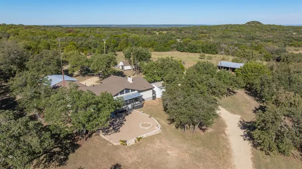 an aerial view of residential houses with outdoor space and trees