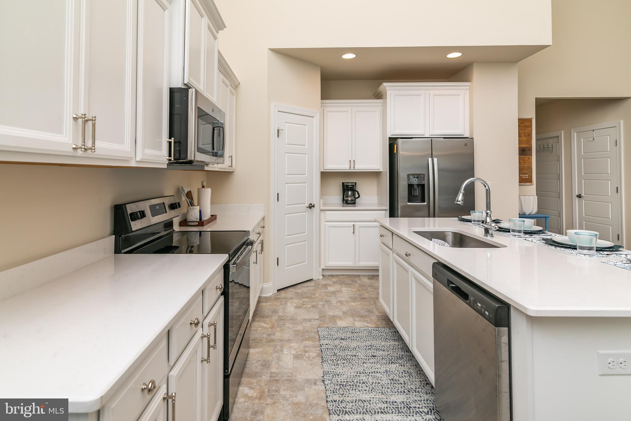 614 Bethany Loop Bethany Beach, DE 19930 - Photo 16 of 92 a kitchen with stainless steel appliances a sink stove and cabinets
