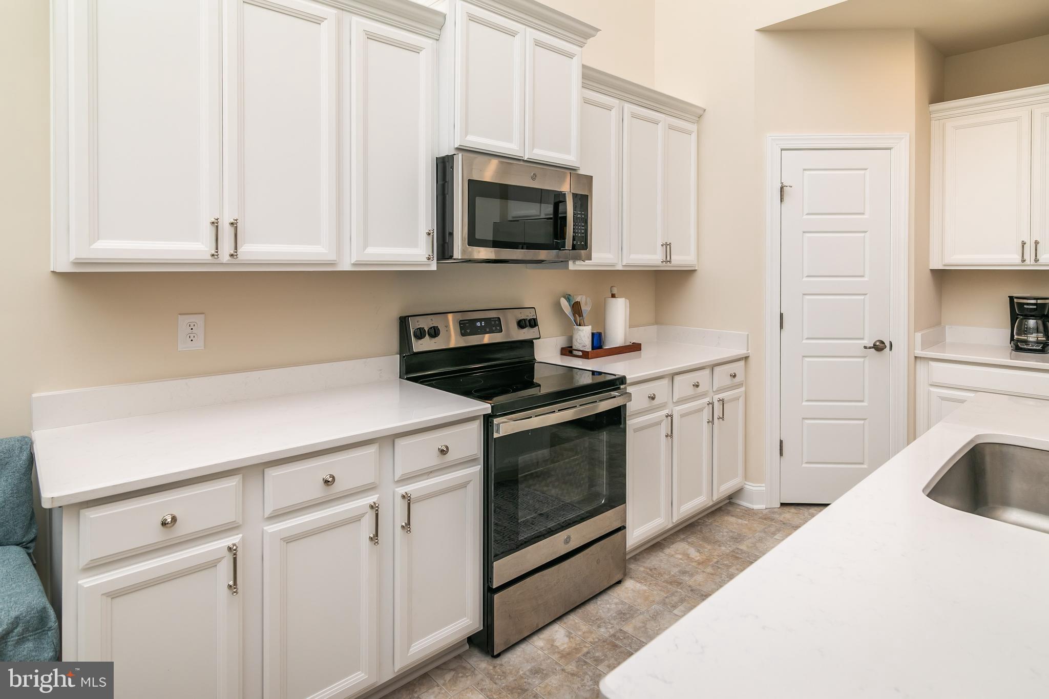 614 Bethany Loop Bethany Beach, DE 19930 - Photo 17 of 92 a kitchen with white cabinets and white appliances