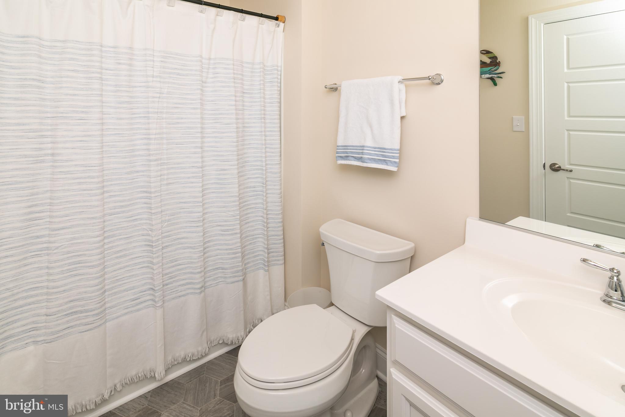 614 Bethany Loop Bethany Beach, DE 19930 - Photo 53 of 92 a white toilet sitting next to a shower curtain
