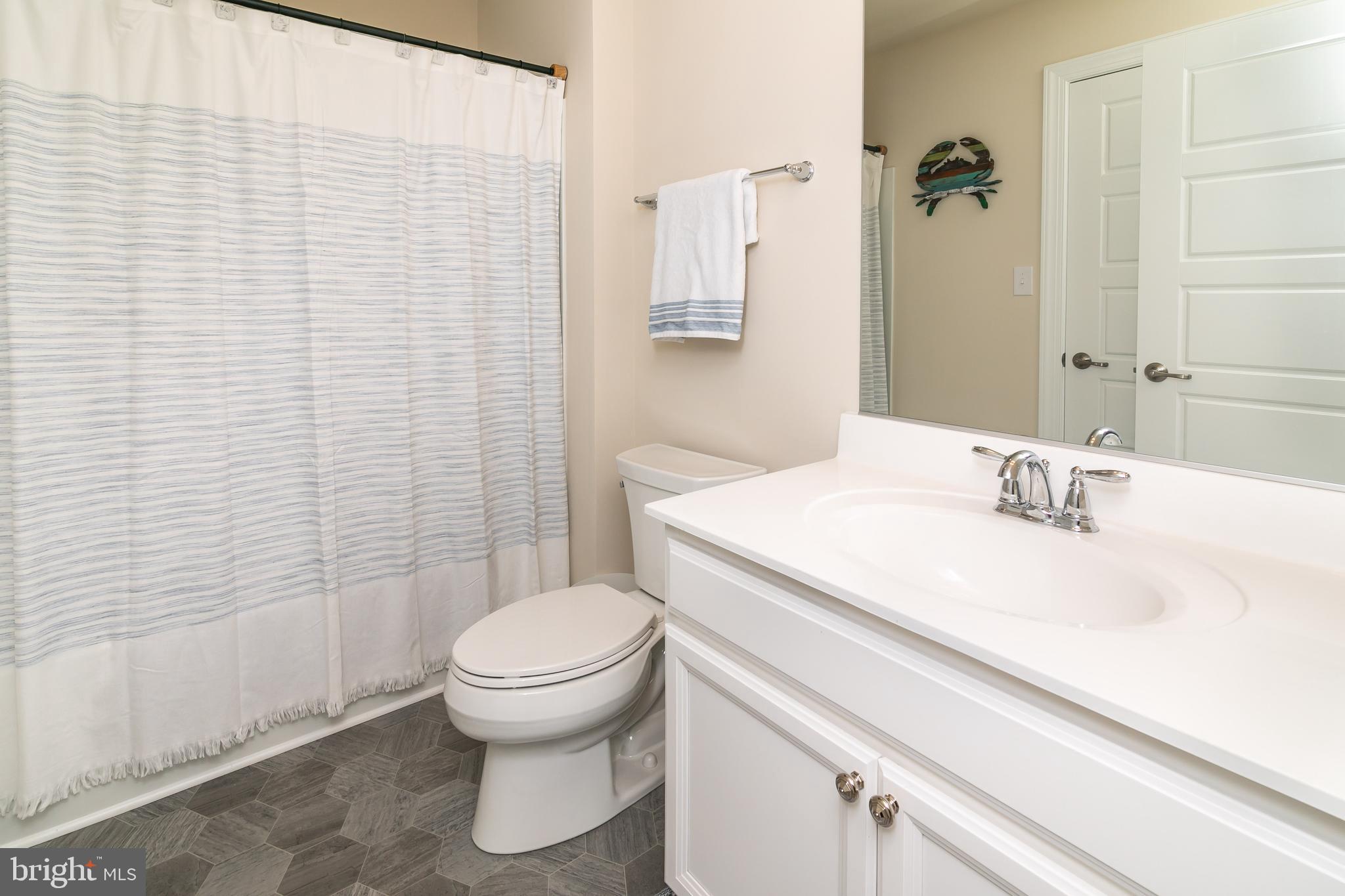 614 Bethany Loop Bethany Beach, DE 19930 - Photo 54 of 92 a bathroom with a sink a toilet and shower curtain