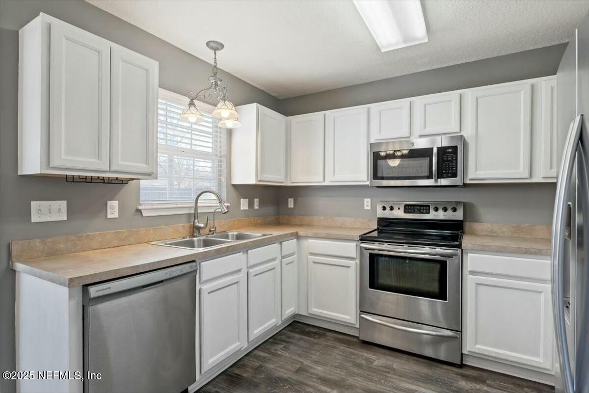 930 Red Fox Way Macclenny, FL 32063 - Photo 14 of 43 a kitchen with stainless steel appliances granite countertop white cabinets a sink and a stove