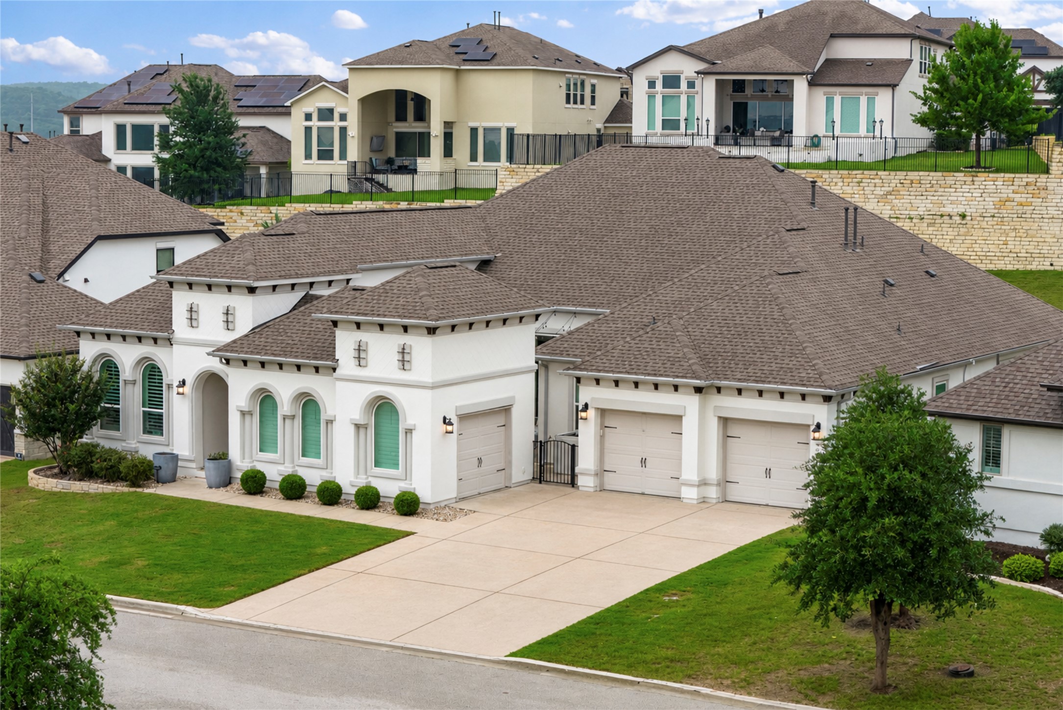 4513 Vieste View Leander, TX 78641 - Photo 39 of 40 Mediterranean-style home featuring a pristine white stucco exterior, arched windows, and a three-car garage