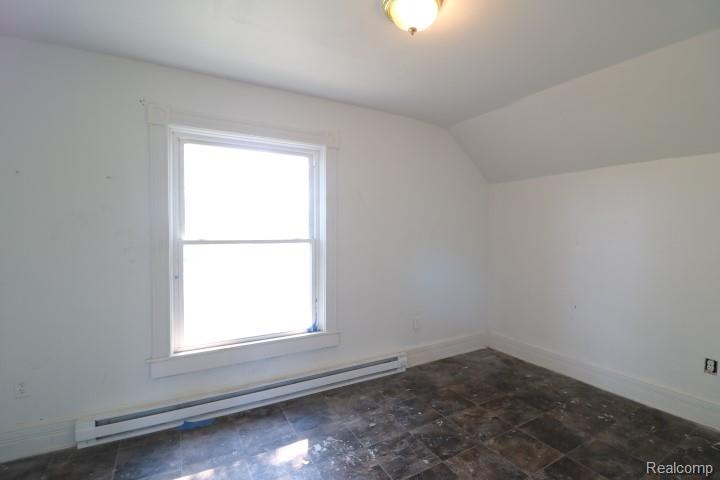 6577 East Deckerville Road Deford, MI 48729 - Photo 17 of 23 Attic space featuring a double-hung window, wall-mounted electric heating unit, and an overhead light fixture