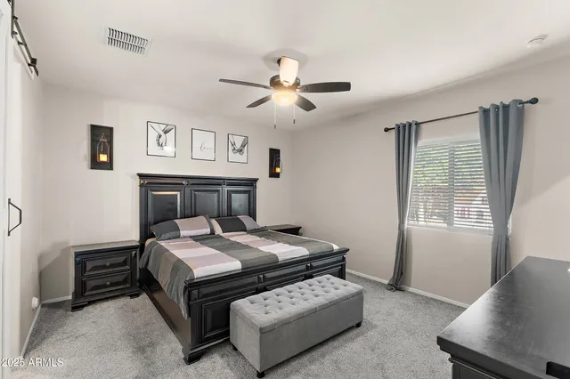 a bedroom with a bed next to a window with a bookshelf