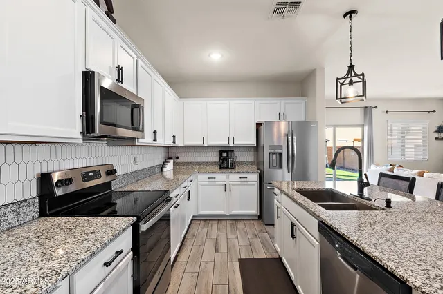 a kitchen with a sink stove top oven and refrigerator