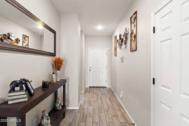 a view of a hallway with workspace and wooden floor