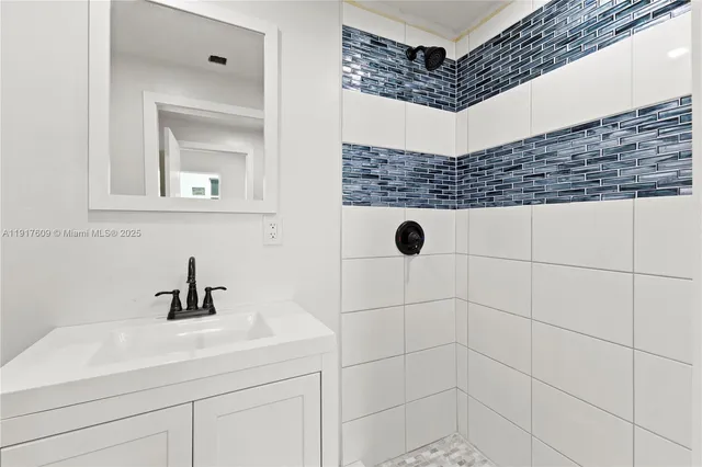 a bathroom with a sink a mirror and shower