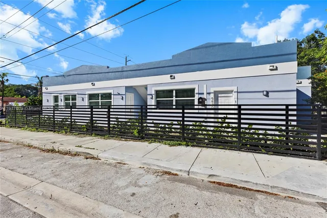 a view of a house with wooden fence