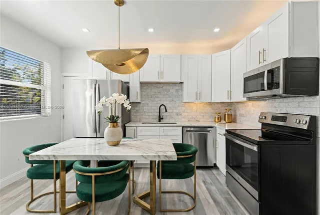 a kitchen with a table chairs microwave and cabinets