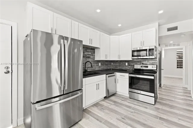 a kitchen with stainless steel appliances a refrigerator stove and microwave
