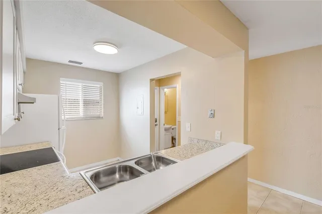 a kitchen with granite countertop white cabinets and white appliances