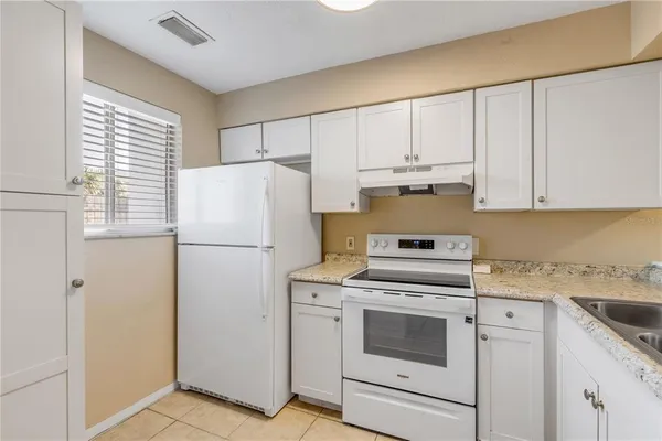 a kitchen with white cabinets and white appliances