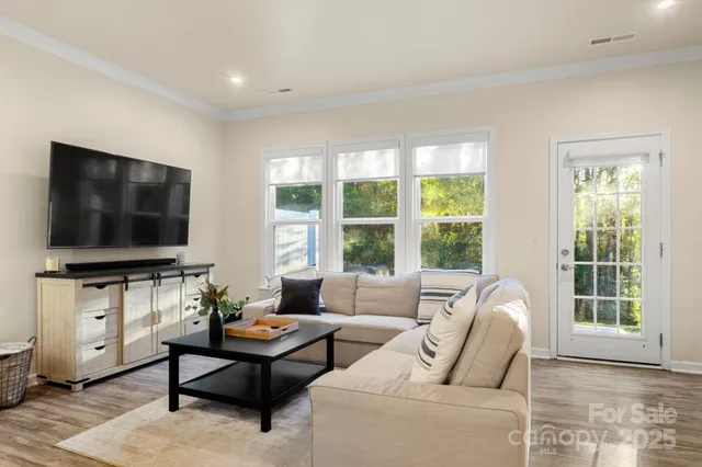 a living room with furniture a flat screen tv and a large window