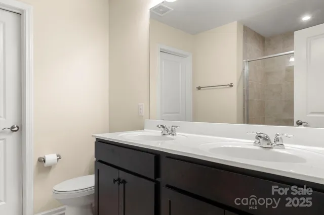 a bathroom with a sink a toilet a shower and a mirror