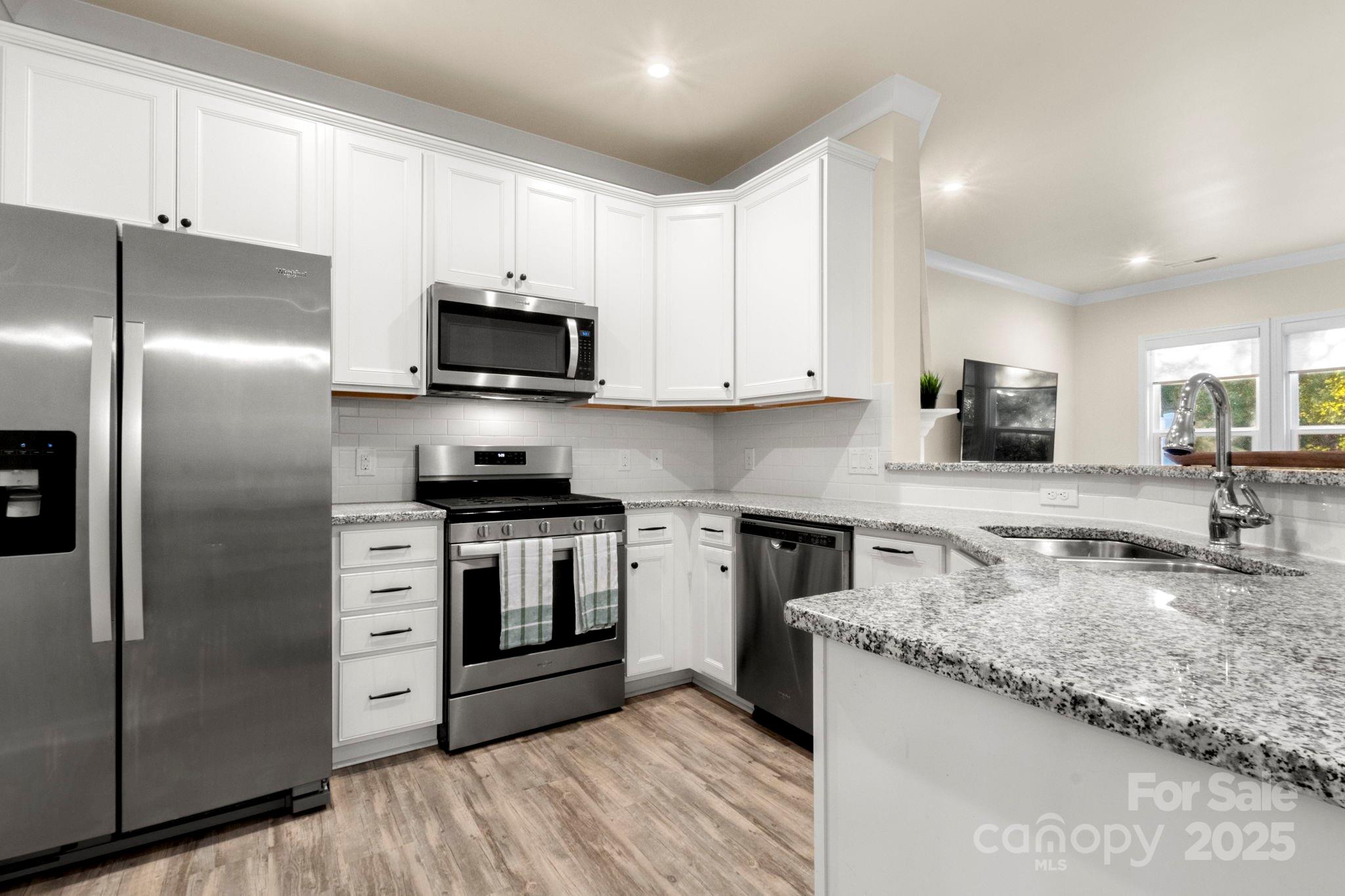 525 Hunters Dance Road Fort Mill, SC 29708 - Photo 5 of 28 a kitchen with granite countertop a refrigerator a sink a stove a microwave and wooden cabinets