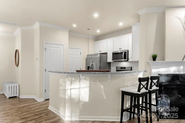 a kitchen with stainless steel appliances granite countertop a stove a sink a microwave a refrigerator and cabinets