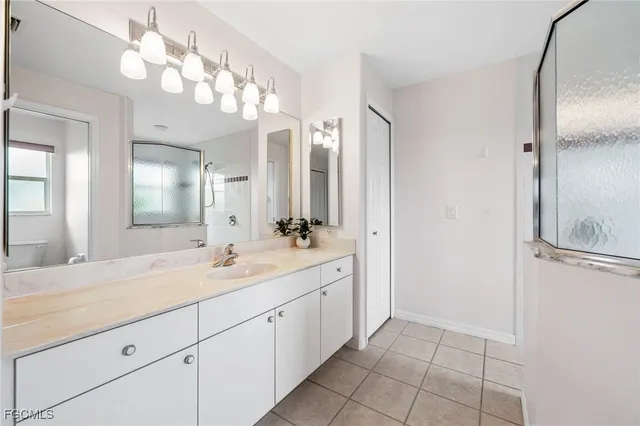 a bedroom with a bed and a lamp on the dresser