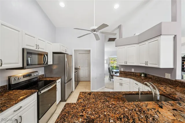 a kitchen with stainless steel appliances granite countertop a sink refrigerator and microwave