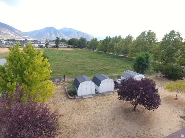 333 West Maple Street Mapleton, UT 84664 - Photo 27 of 35 Expansive grounds featuring a verdant field, three storage sheds, and a backdrop of mountainous terrain