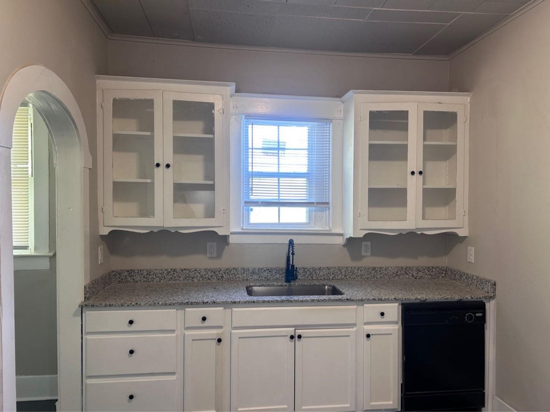1925 11th Street Port Arthur, TX 77640 - Photo 6 of 28 a kitchen with granite countertop a sink and cabinets