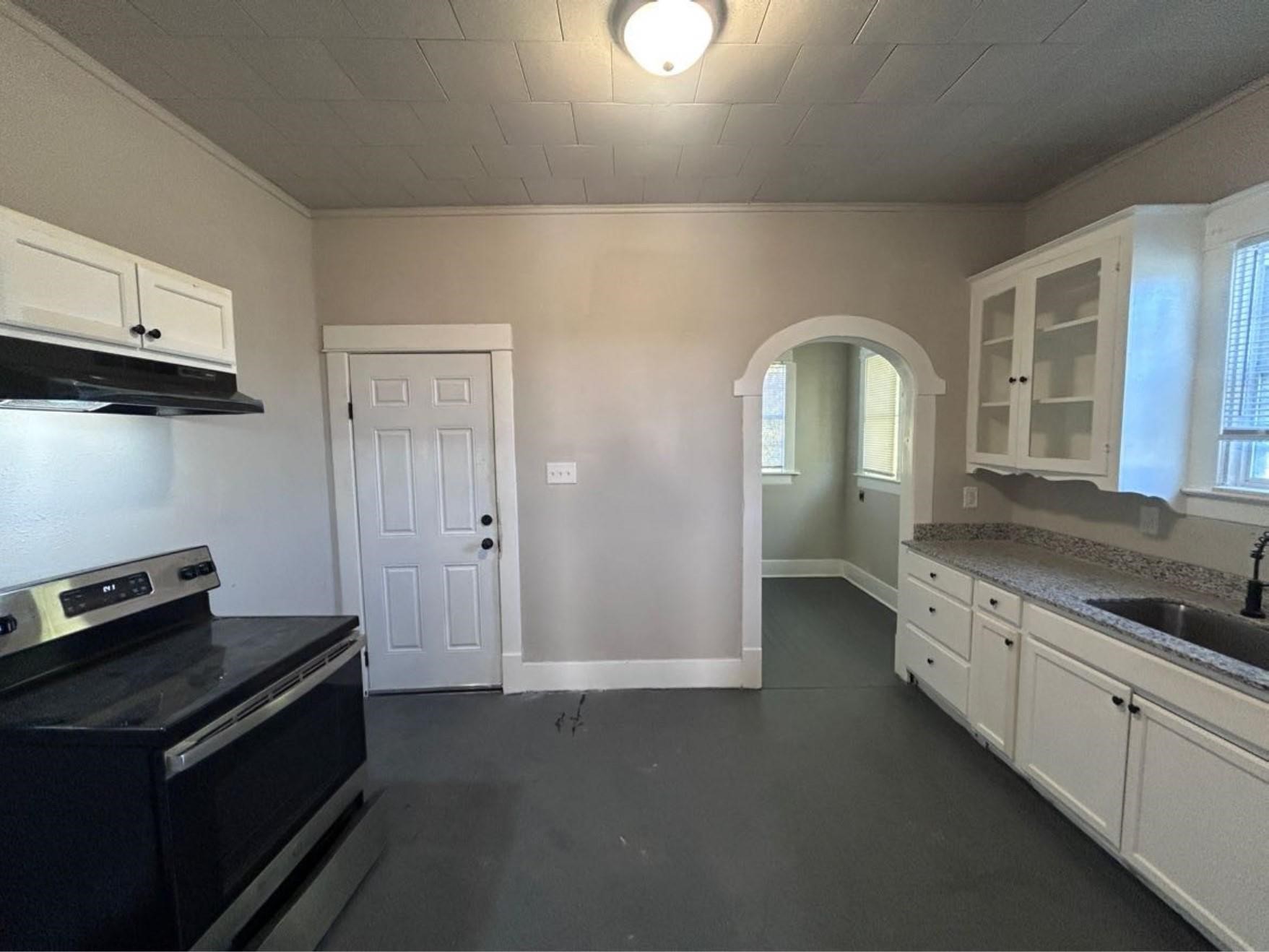 1925 11th Street Port Arthur, TX 77640 - Photo 7 of 28 a kitchen with granite countertop a stove and cabinets