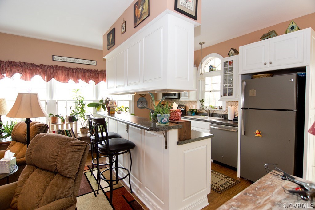 301 Slaughter Road Keysville, VA 23947 - Photo 9 of 50 a kitchen with stainless steel appliances kitchen island granite countertop a refrigerator a stove a sink and white cabinets with wooden floor