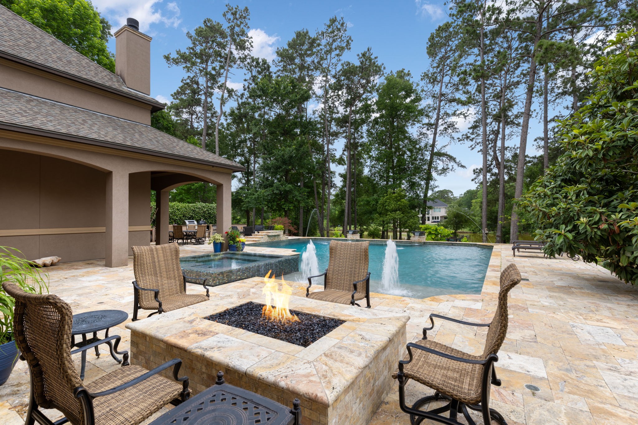 Spectacular backyard retreat designed for entertaining with over 2,000 SF of travertine decking, covered patio space, mature trees, and breathtaking lake views. A built-in poolside gas fire pit creates the perfect gathering place for evenings with family and friends.