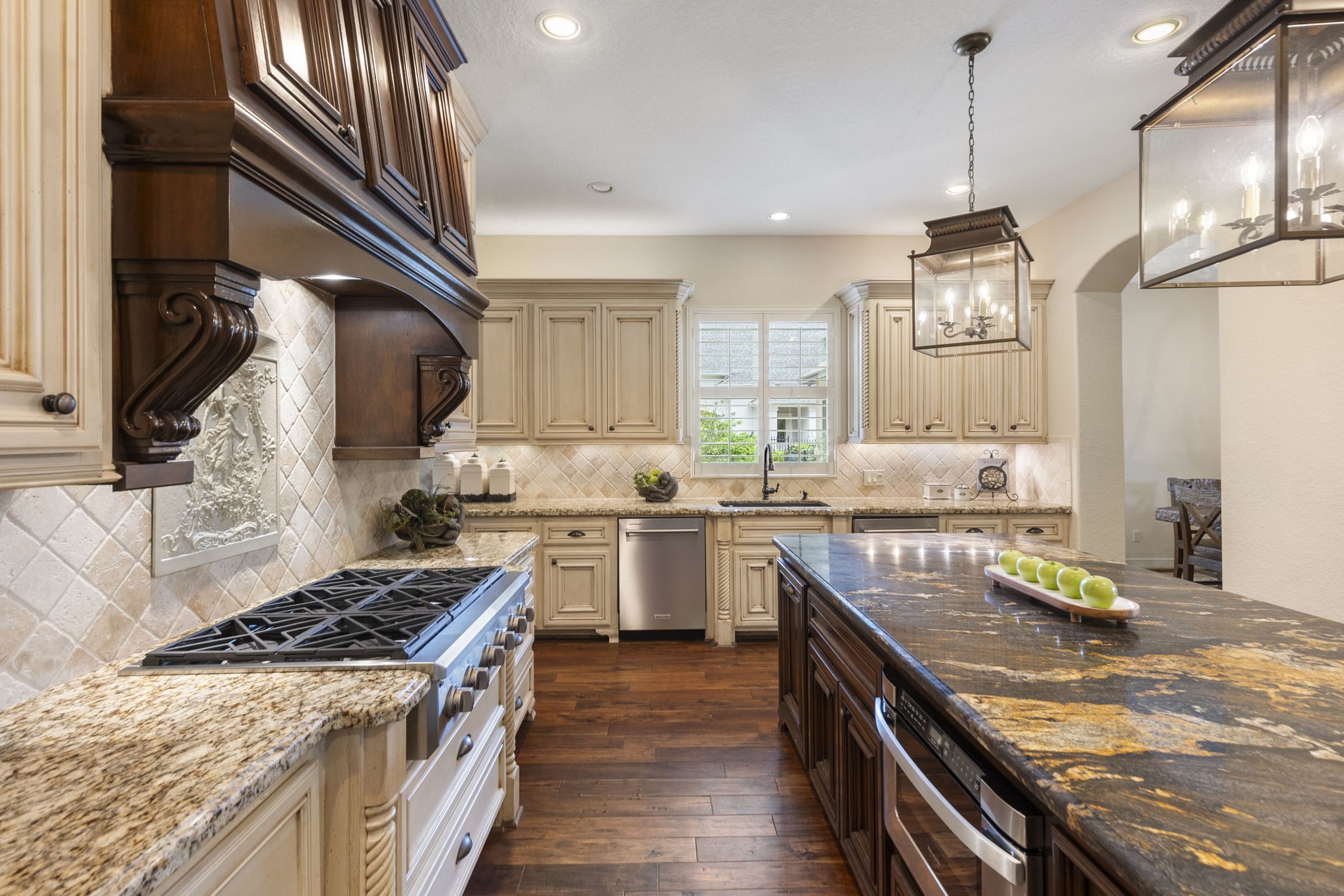 28227 KAILEES Court Spring, TX 77386 - Photo 11 of 48 Custom vent hood anchors the Kitchen with a beautiful tumbled stone backsplash, under-cabinet and upper accent lighting, and a single-basin composite sink perfectly positioned beneath a window for natural light.