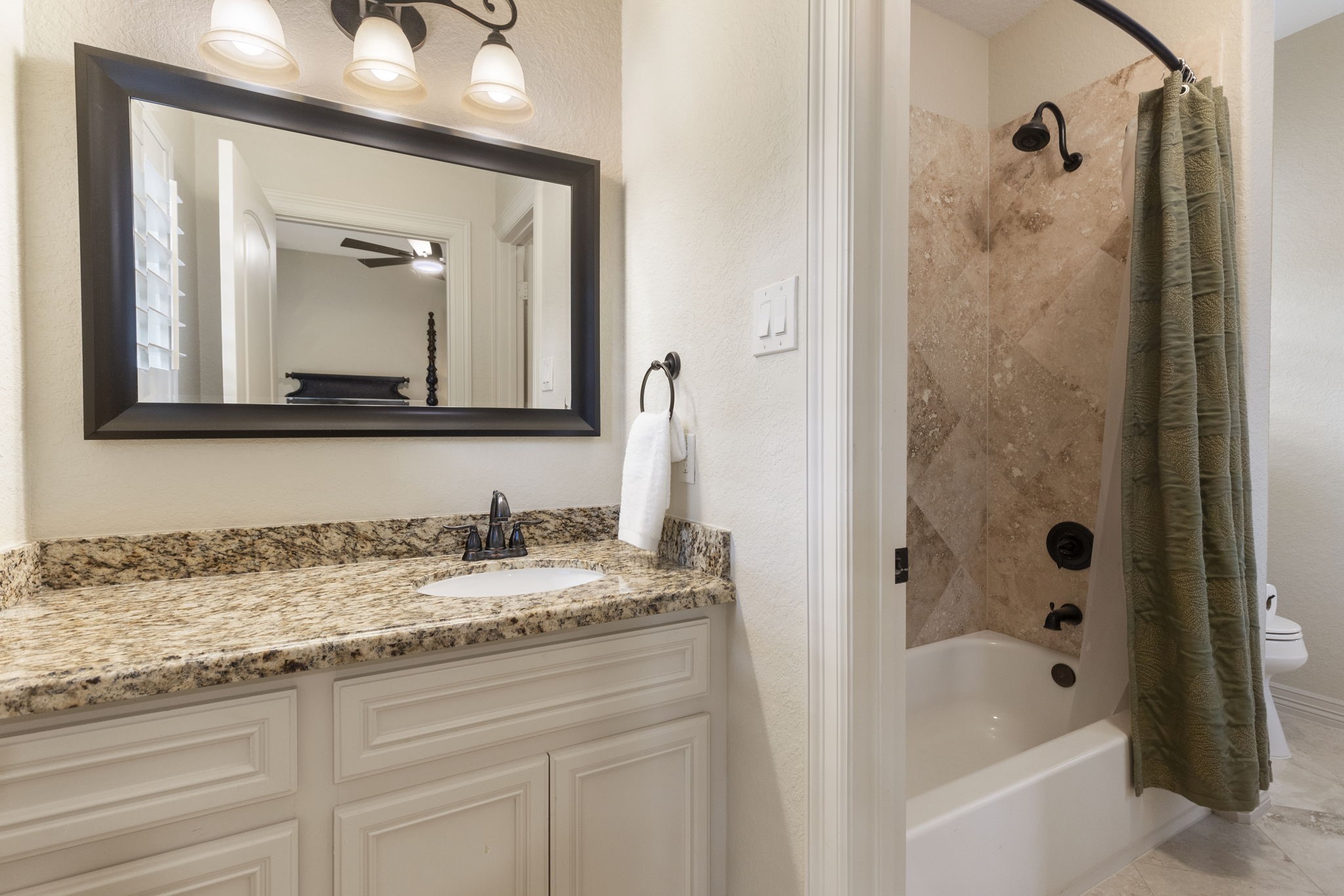 28227 KAILEES Court Spring, TX 77386 - Photo 26 of 48 a bathroom with a granite countertop sink mirror and a bathtub