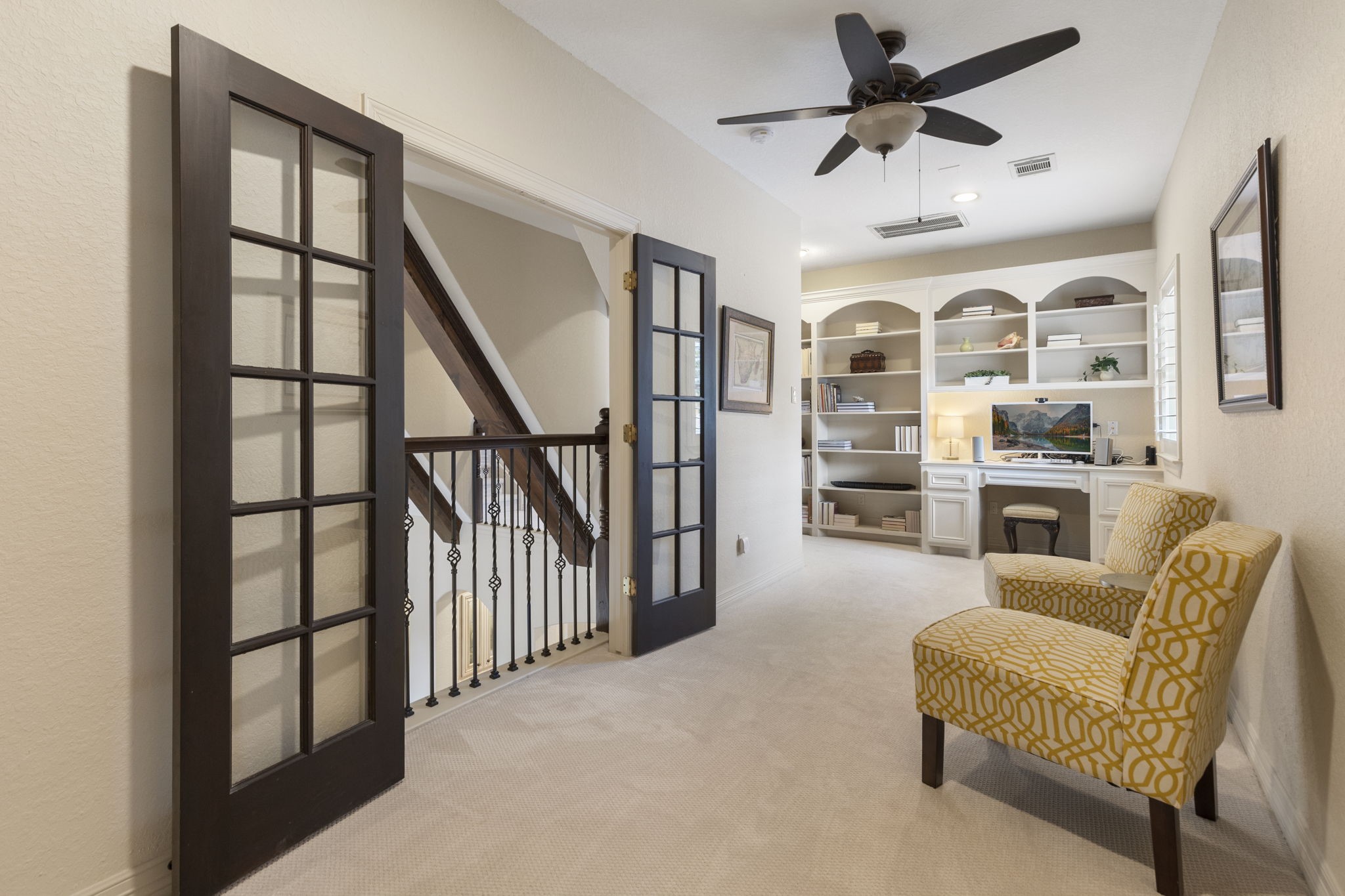 28227 KAILEES Court Spring, TX 77386 - Photo 32 of 48 Inviting upstairs library retreat with arched custom built-ins, integrated desk, updated carpet, ceiling fan, and a charming Juliet balcony with French doors.