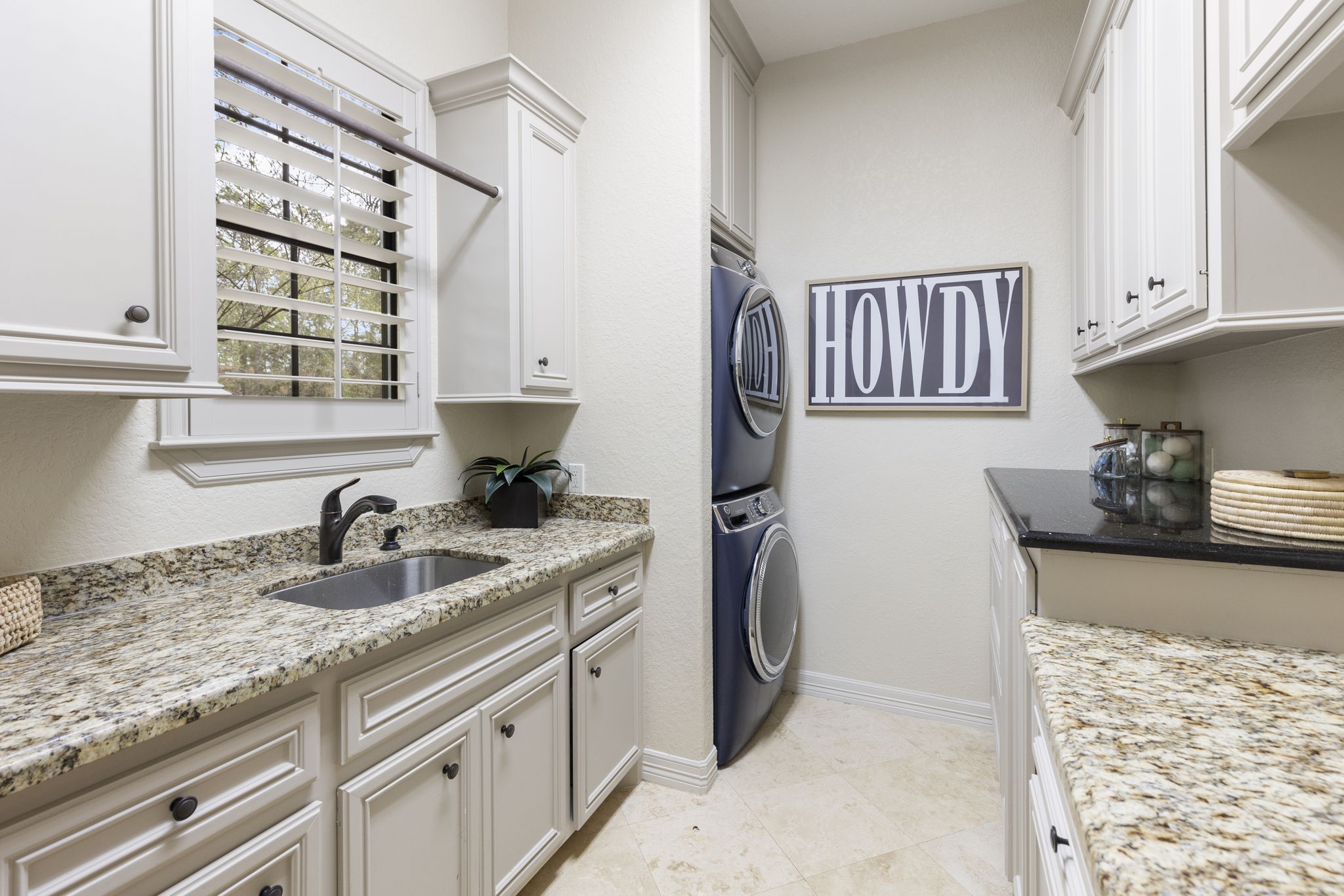 28227 KAILEES Court Spring, TX 77386 - Photo 35 of 48 Spacious and thoughtfully designed Utility Room with extensive granite countertop workspace, custom built-ins on both sides, Travertine flooring, and a utility sink. Ideally located off the side entry for everyday convenience.