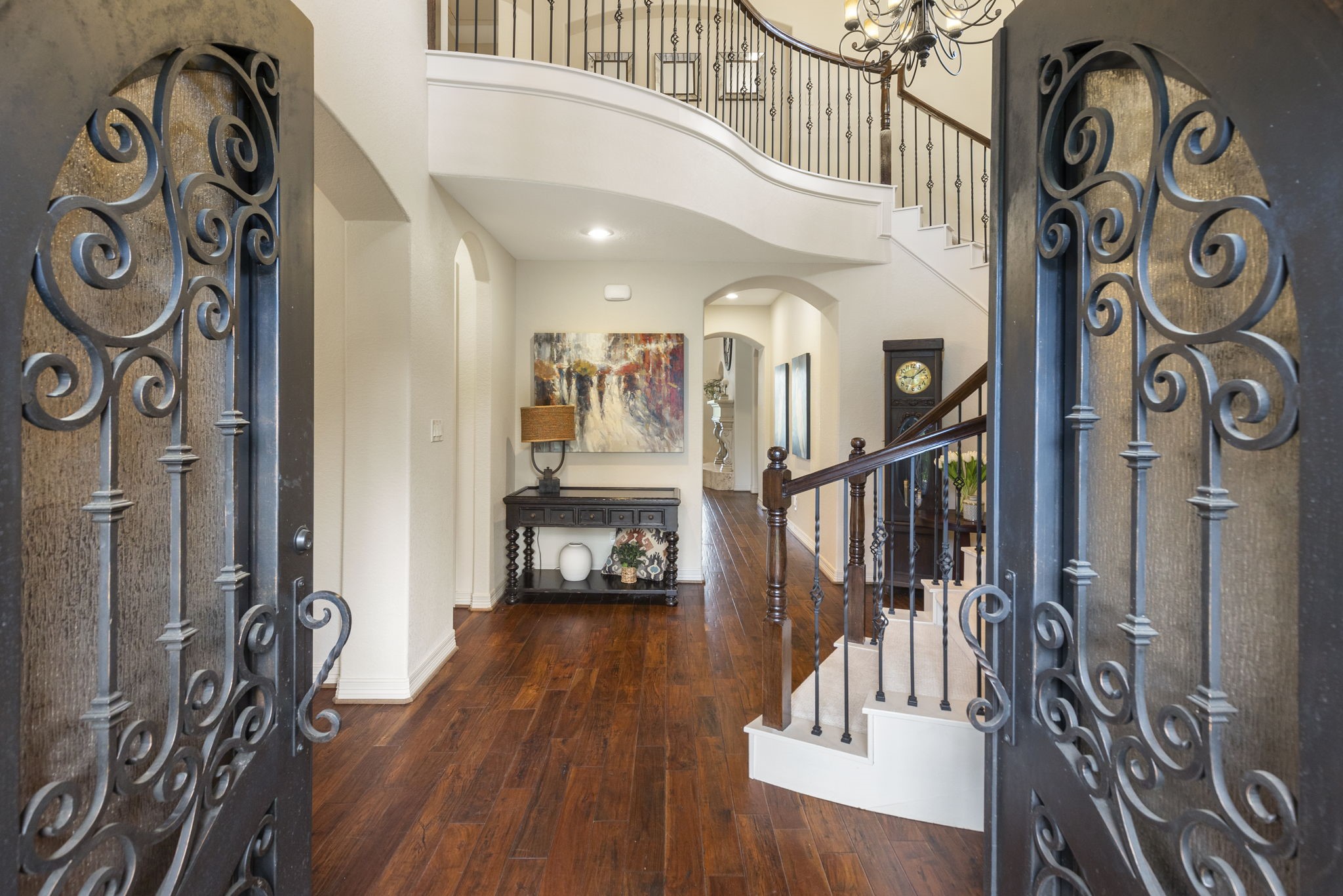 28227 KAILEES Court Spring, TX 77386 - Photo 4 of 48 Grand two-story Foyer featuring arched iron double doors, rich wood flooring, and a dramatic chandelier that sets the tone for the home’s architectural elegance.