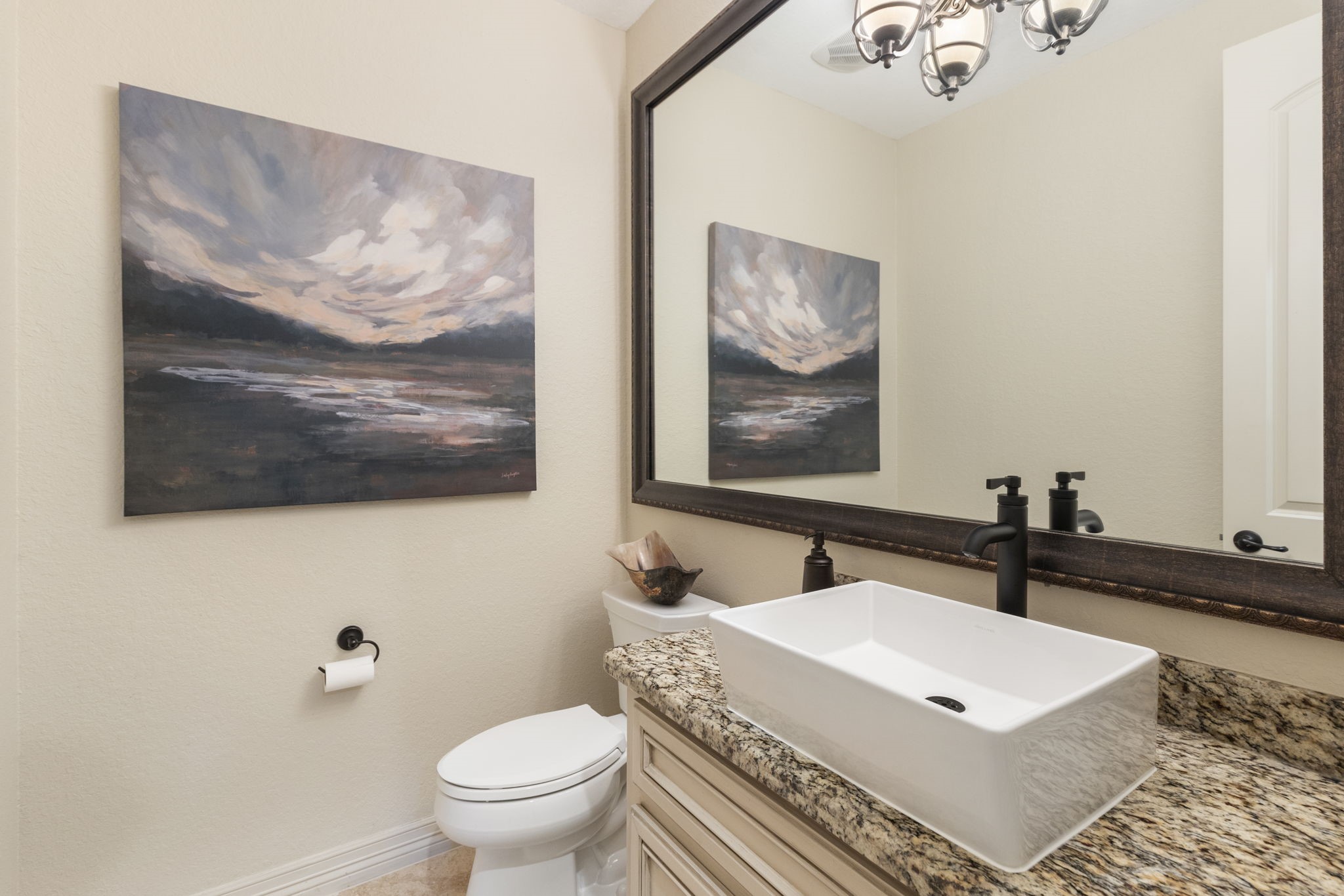 28227 KAILEES Court Spring, TX 77386 - Photo 10 of 48 Elegant Powder Bath off the foyer featuring Travertine flooring, a raised vessel sink, granite countertop, and a large framed mirror—one of two powder baths in the home.