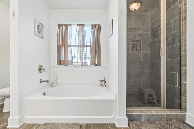 a white bath tub sitting next to a shower
