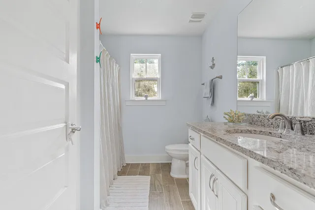 a bathroom with a granite countertop sink toilet and shower