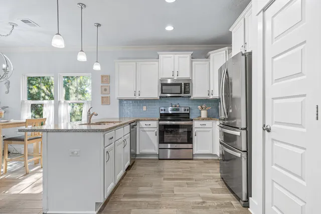 a kitchen with stainless steel appliances a refrigerator sink and cabinets