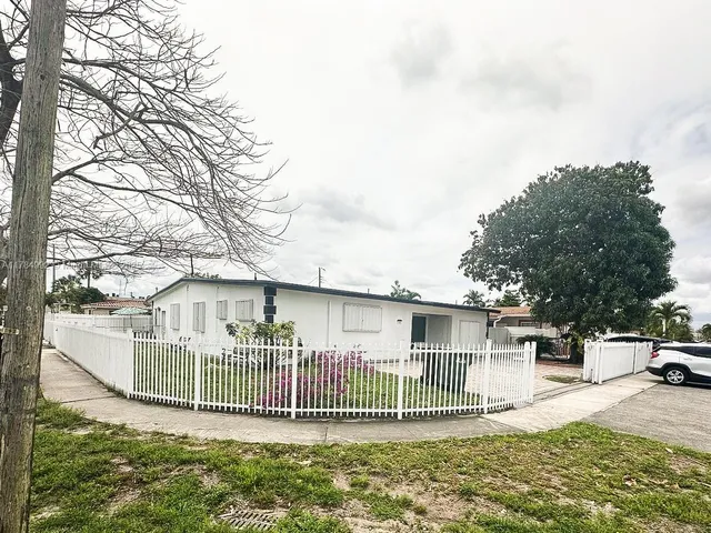 a view of a house with a patio and a yard