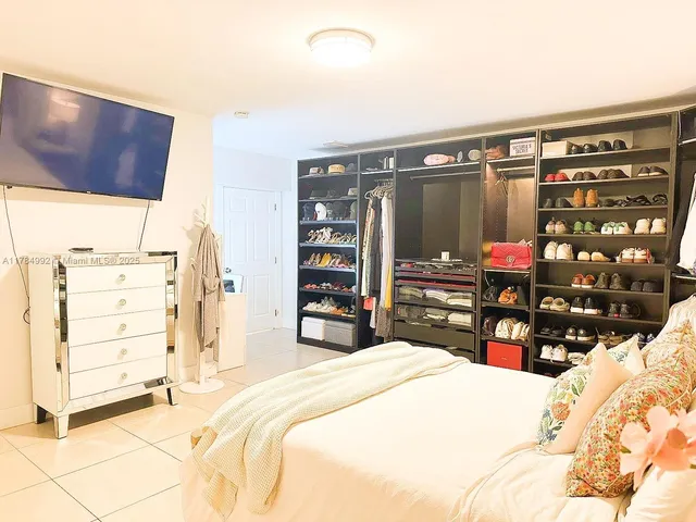 a bedroom with a bed a dresser and book shelf