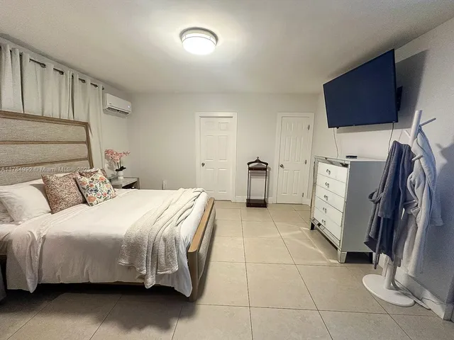 a bedroom with a bed and a flat screen tv