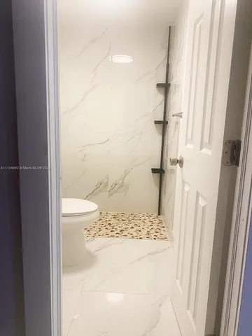 a bathroom with a granite countertop shower and a sink