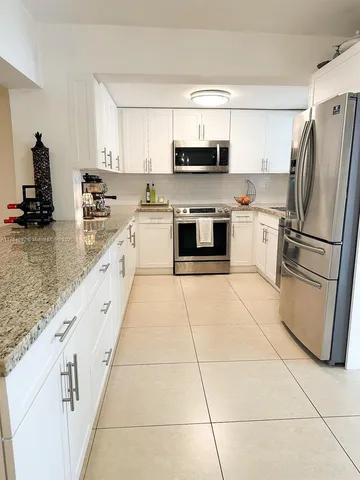 a large kitchen with a stove a microwave and a refrigerator