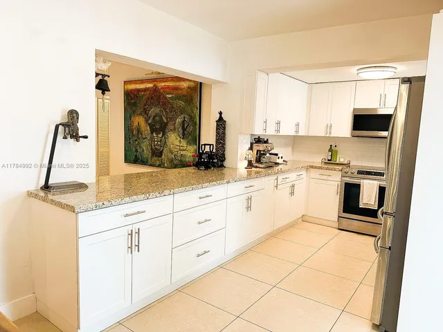 a kitchen with white cabinets and white appliances