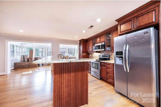 a kitchen with stainless steel appliances granite countertop a refrigerator stove top oven and sink