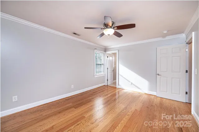 a view of empty room with wooden floor