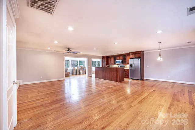 a view of empty room with wooden floor