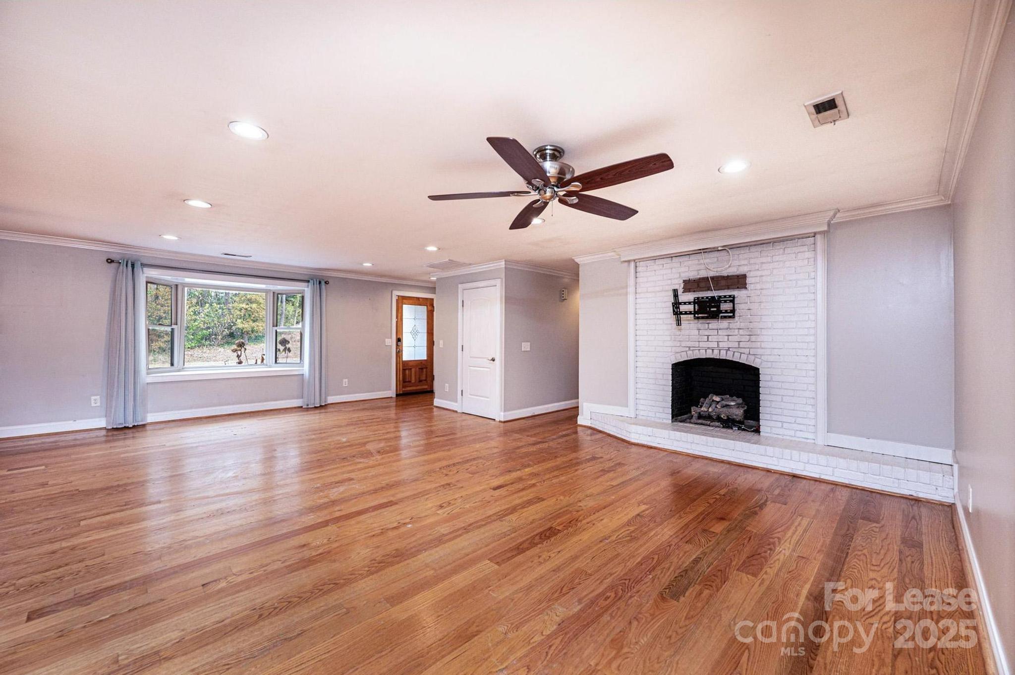 1060 26th Avenue Northeast Hickory, NC 28601 - Photo 7 of 29 an empty room with wooden floor and a fireplace