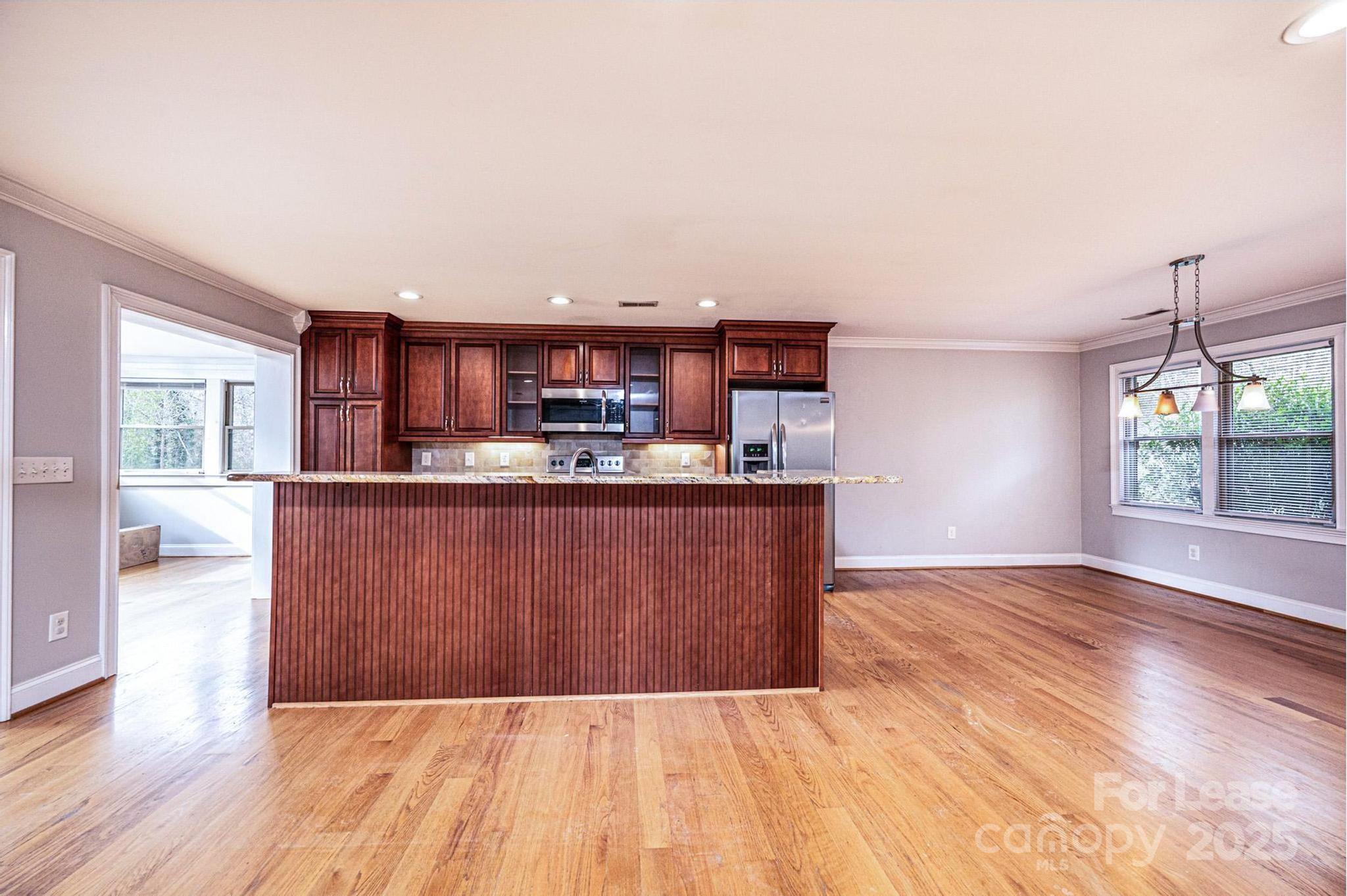 1060 26th Avenue Northeast Hickory, NC 28601 - Photo 9 of 29 a living room with kitchen island granite countertop wooden floor and a view of kitchen